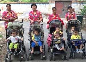 ayis with children in strollers outside